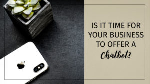 Text: Is it time for your business to offer a chatbot? Background - black desktop with plant and silver iPhone